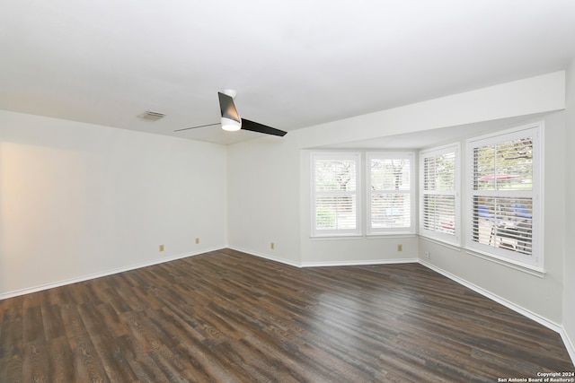 spare room featuring plenty of natural light, dark wood-type flooring, and ceiling fan