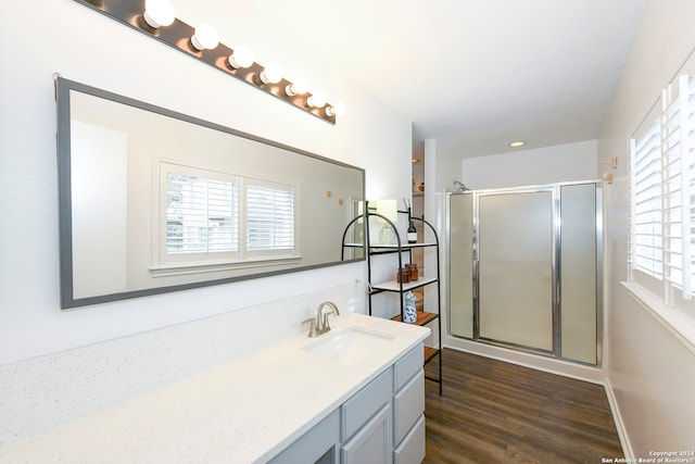 bathroom with vanity, hardwood / wood-style flooring, and walk in shower