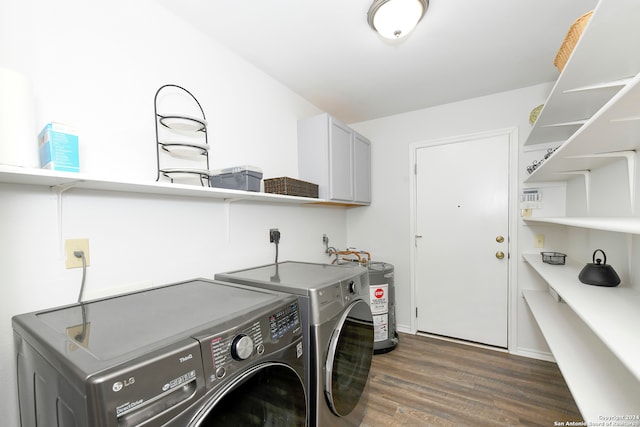 clothes washing area featuring washing machine and clothes dryer, electric water heater, cabinets, and dark hardwood / wood-style floors