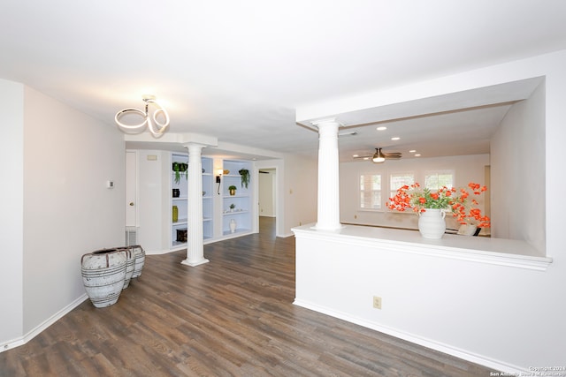 spare room featuring dark hardwood / wood-style floors, ceiling fan, ornate columns, and a fireplace