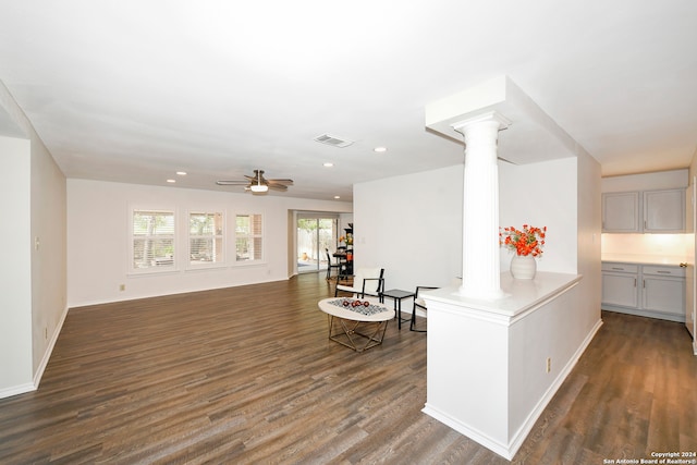 living room with ornate columns, ceiling fan, and dark wood-type flooring