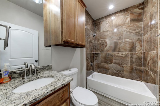 full bathroom with vanity, tiled shower / bath combo, and toilet