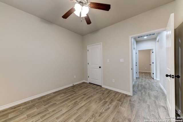 unfurnished bedroom with ceiling fan and light wood-type flooring