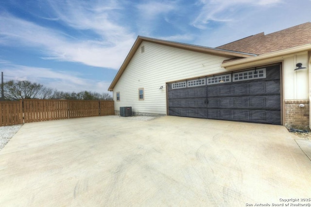 view of side of home with a garage and cooling unit