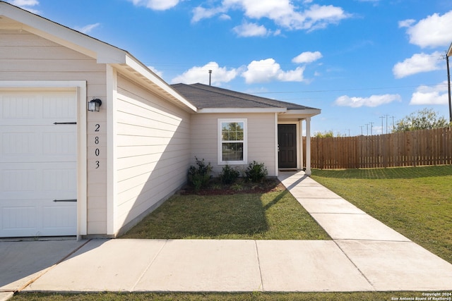 property entrance with a yard and a garage