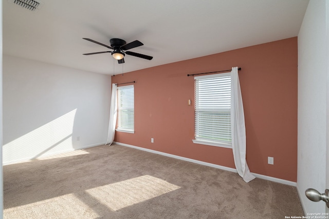 empty room featuring ceiling fan and light carpet