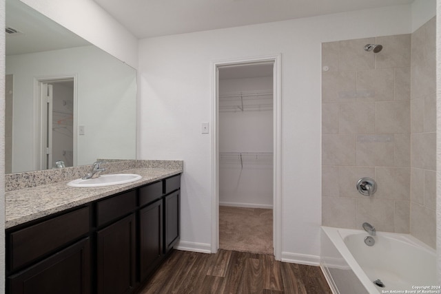 bathroom featuring vanity, hardwood / wood-style flooring, and tiled shower / bath