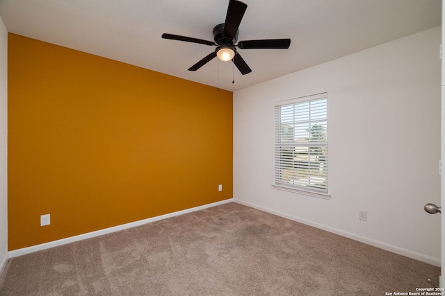 unfurnished room with ceiling fan and carpet