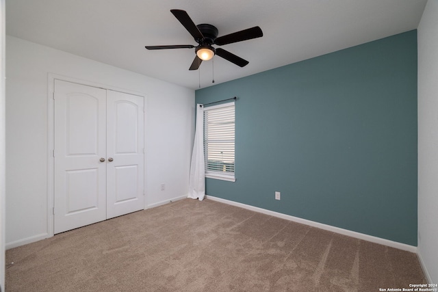 unfurnished bedroom featuring carpet flooring, ceiling fan, and a closet