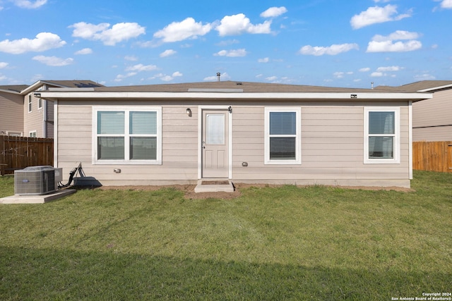 rear view of house featuring a yard and central AC unit