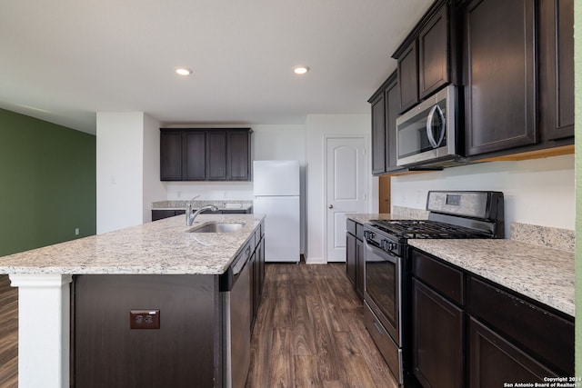 kitchen with sink, dark wood-type flooring, appliances with stainless steel finishes, and an island with sink