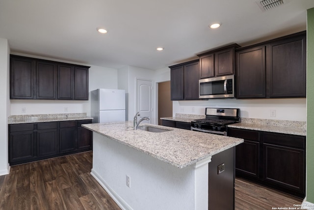 kitchen featuring sink, dark hardwood / wood-style flooring, stainless steel appliances, and an island with sink