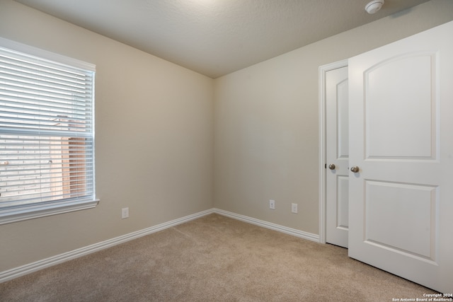 carpeted empty room featuring a textured ceiling