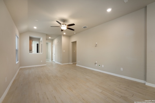 empty room with light wood-type flooring, vaulted ceiling, and ceiling fan