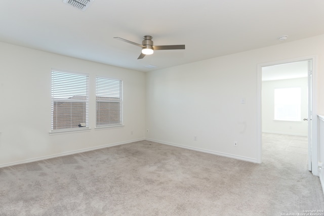 unfurnished room featuring light colored carpet and ceiling fan