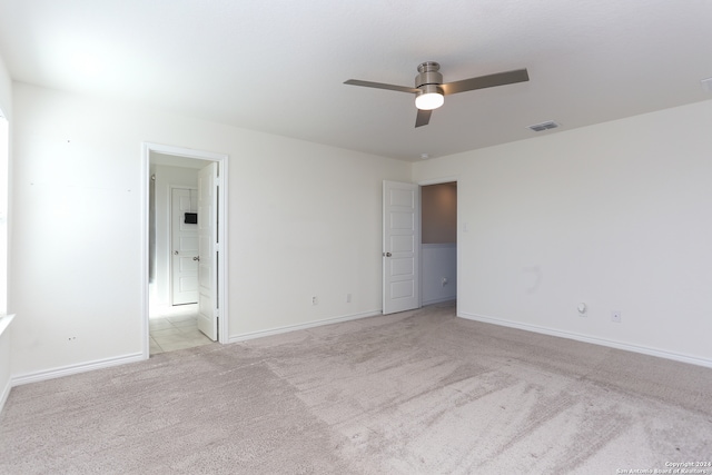 unfurnished room with ceiling fan and light carpet