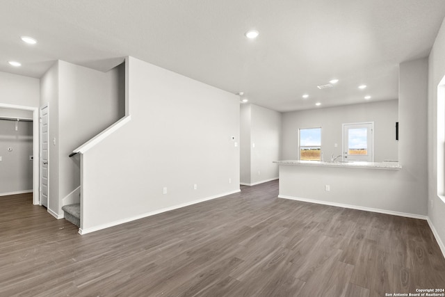 2087 Olivia Dr, New Braunfels, TX 78130 - unfurnished living room with dark wood-type flooring, baseboards, stairs, and recessed lighting