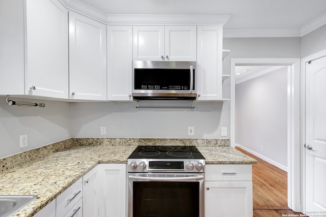 kitchen with light stone countertops, stainless steel appliances, hardwood / wood-style floors, white cabinets, and ornamental molding