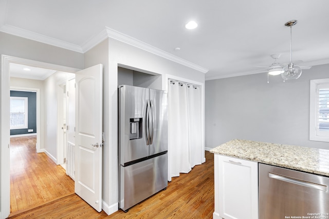 kitchen with light hardwood / wood-style flooring, stainless steel appliances, and ornamental molding