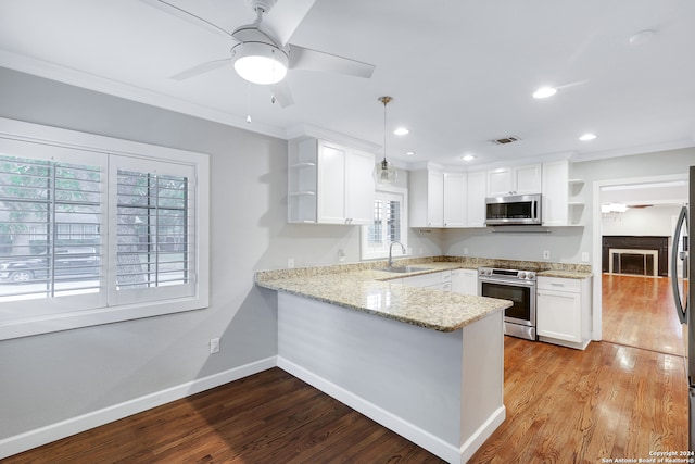 kitchen featuring white cabinetry, kitchen peninsula, decorative light fixtures, appliances with stainless steel finishes, and light wood-type flooring