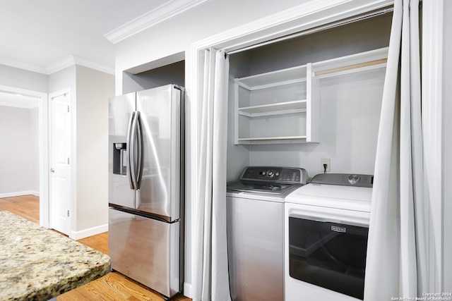 clothes washing area featuring separate washer and dryer, light hardwood / wood-style flooring, and ornamental molding