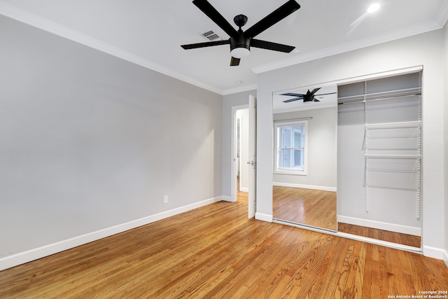 unfurnished bedroom with ceiling fan, a closet, light hardwood / wood-style floors, and ornamental molding