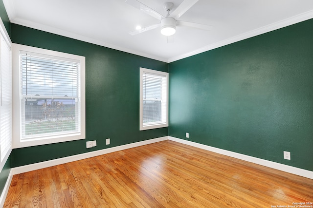 empty room featuring ceiling fan, plenty of natural light, light hardwood / wood-style floors, and ornamental molding