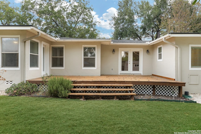 rear view of house with a deck, a yard, and french doors