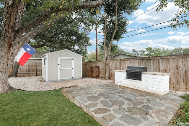 view of patio / terrace with a grill and a storage shed