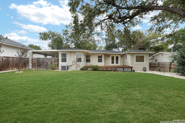 rear view of property featuring a lawn, central AC unit, and a carport