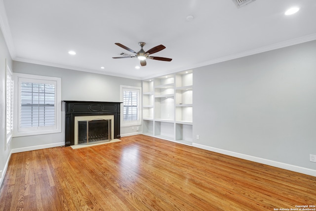 unfurnished living room with hardwood / wood-style floors, ceiling fan, ornamental molding, and built in shelves