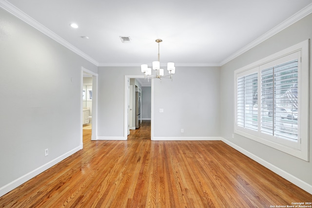 spare room with ornamental molding, light wood-type flooring, and a healthy amount of sunlight