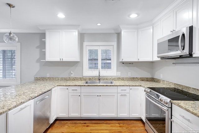 kitchen featuring appliances with stainless steel finishes, white cabinetry, pendant lighting, and sink