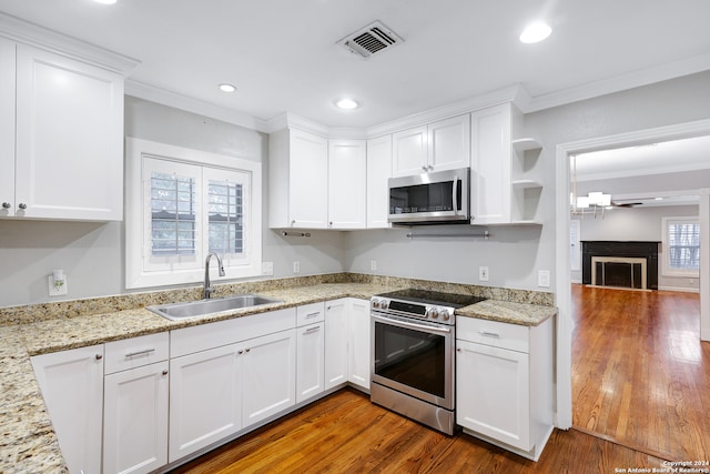 kitchen with a wealth of natural light, white cabinetry, sink, and appliances with stainless steel finishes