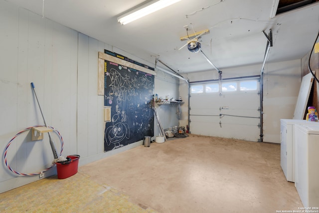 garage with a garage door opener and independent washer and dryer