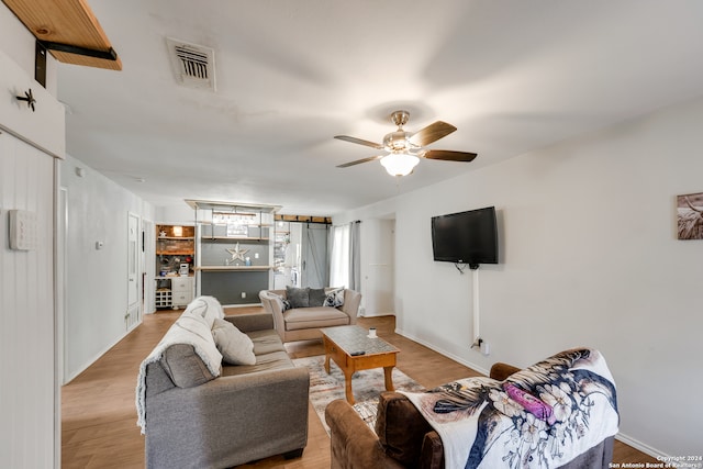 living room featuring ceiling fan and light hardwood / wood-style floors