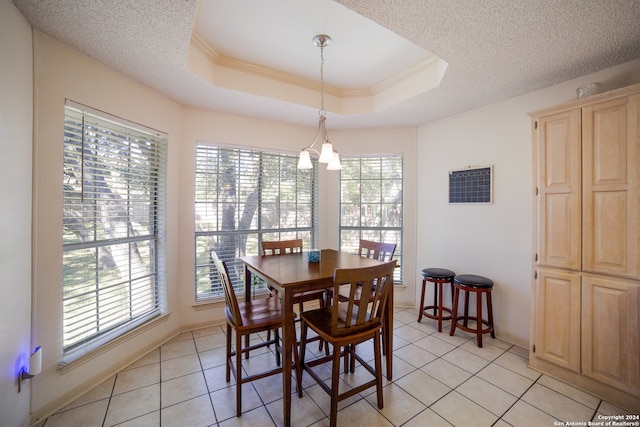 dining area with a tray ceiling, light tile patterned floors, and a healthy amount of sunlight