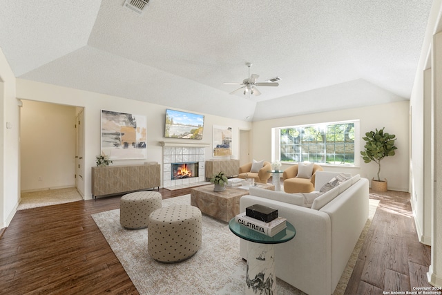 living room with hardwood / wood-style floors, ceiling fan, a fireplace, and vaulted ceiling