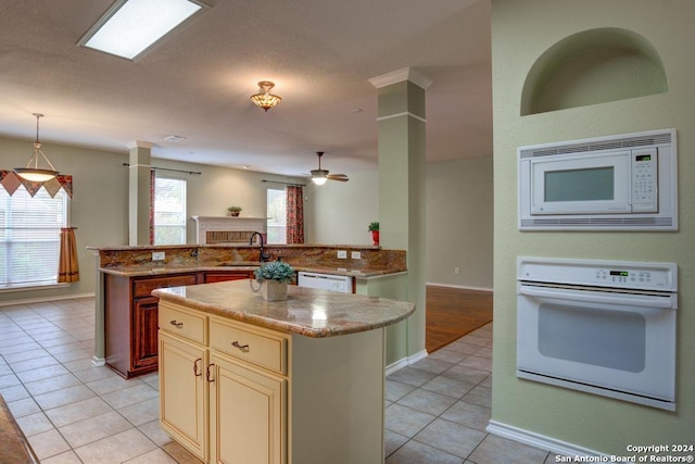 kitchen featuring pendant lighting, a center island, sink, and white appliances