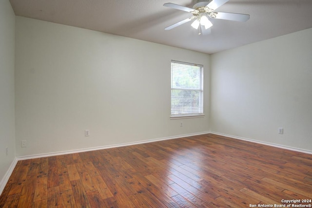 empty room with ceiling fan and dark hardwood / wood-style flooring