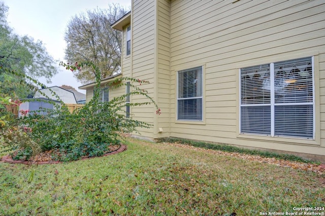 view of side of home with a yard