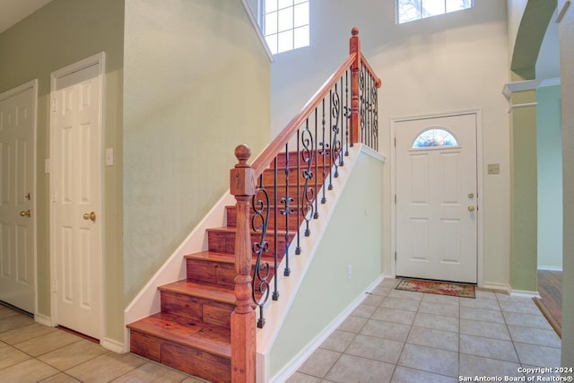 tiled foyer with a towering ceiling