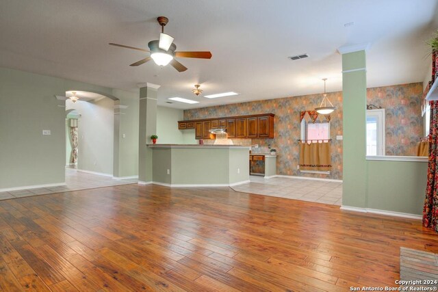 unfurnished living room with ceiling fan and light wood-type flooring