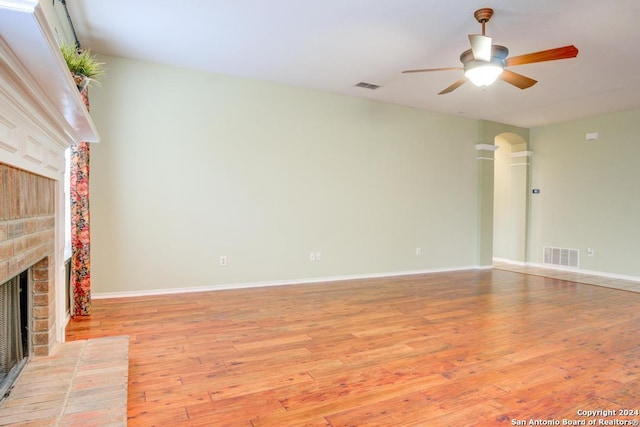 unfurnished living room featuring ceiling fan, a fireplace, and light hardwood / wood-style flooring