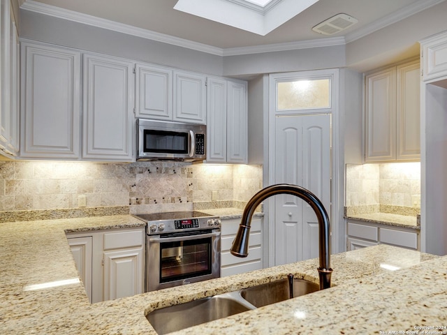 kitchen featuring backsplash, white cabinetry, crown molding, and appliances with stainless steel finishes