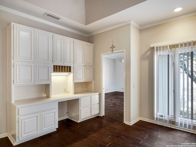 unfurnished office featuring ornamental molding, built in desk, and dark wood-type flooring