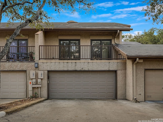 multi unit property featuring a balcony and a garage