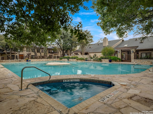 view of pool featuring a patio area and a community hot tub