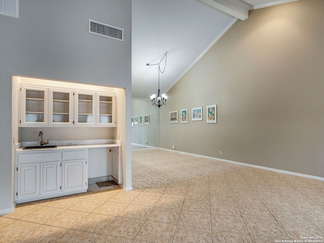 interior space featuring beam ceiling, sink, high vaulted ceiling, a notable chandelier, and pendant lighting