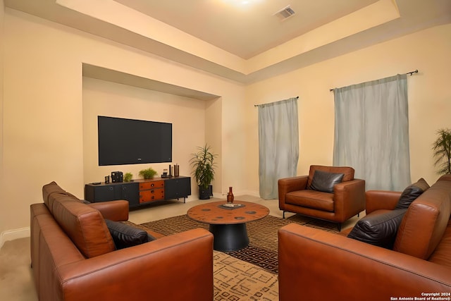 living room with light colored carpet and a tray ceiling